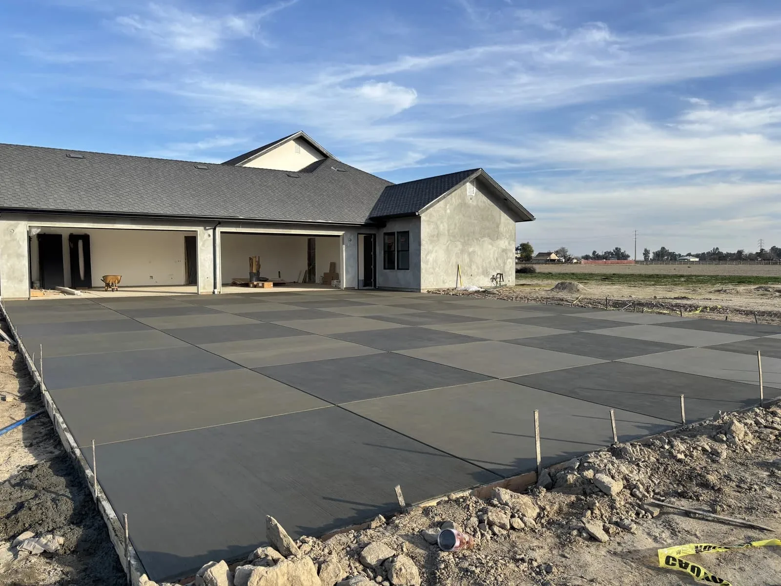 Freshly poured concrete driveway in front of a new ranch style home, concrete driveways