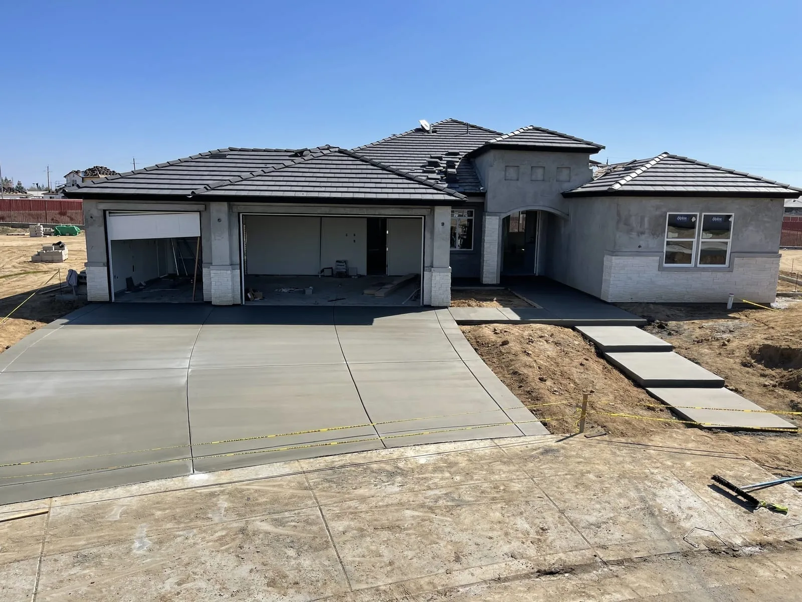 New broom finished concrete driveway at a stucco home, concrete driveways