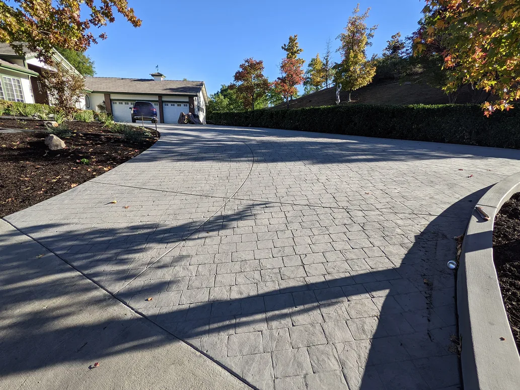 Stamped concrete driveway curving up a slope to a garage, concrete driveways