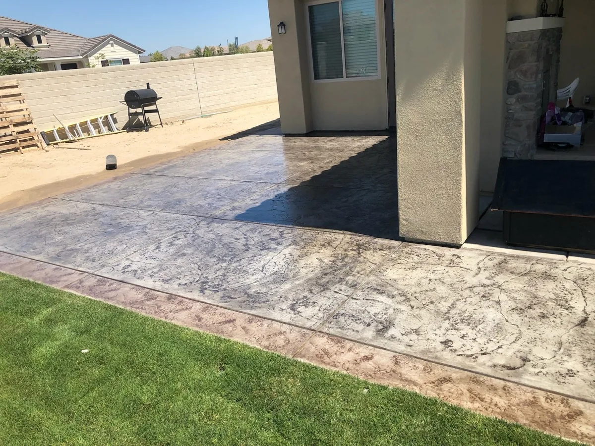 Stamped concrete patio wrapping the back of a stucco home, concrete patios