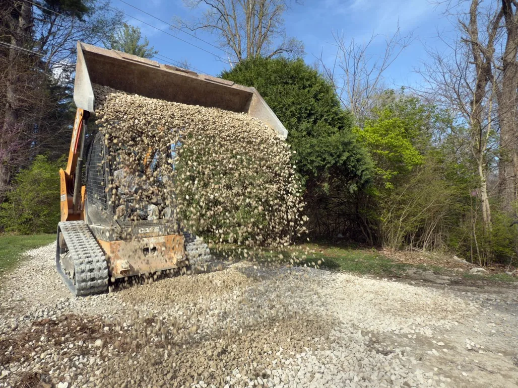 Track loader dumping crushed rock onto a drive, gravel driveways